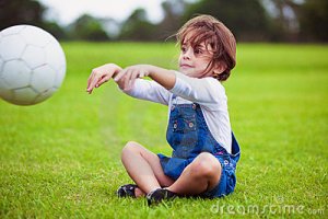 young-girl-sitting-grass-throwing-ball-13791746