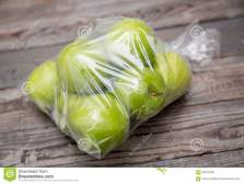 apple-fruit-plastic-bag-wood-table-56372468